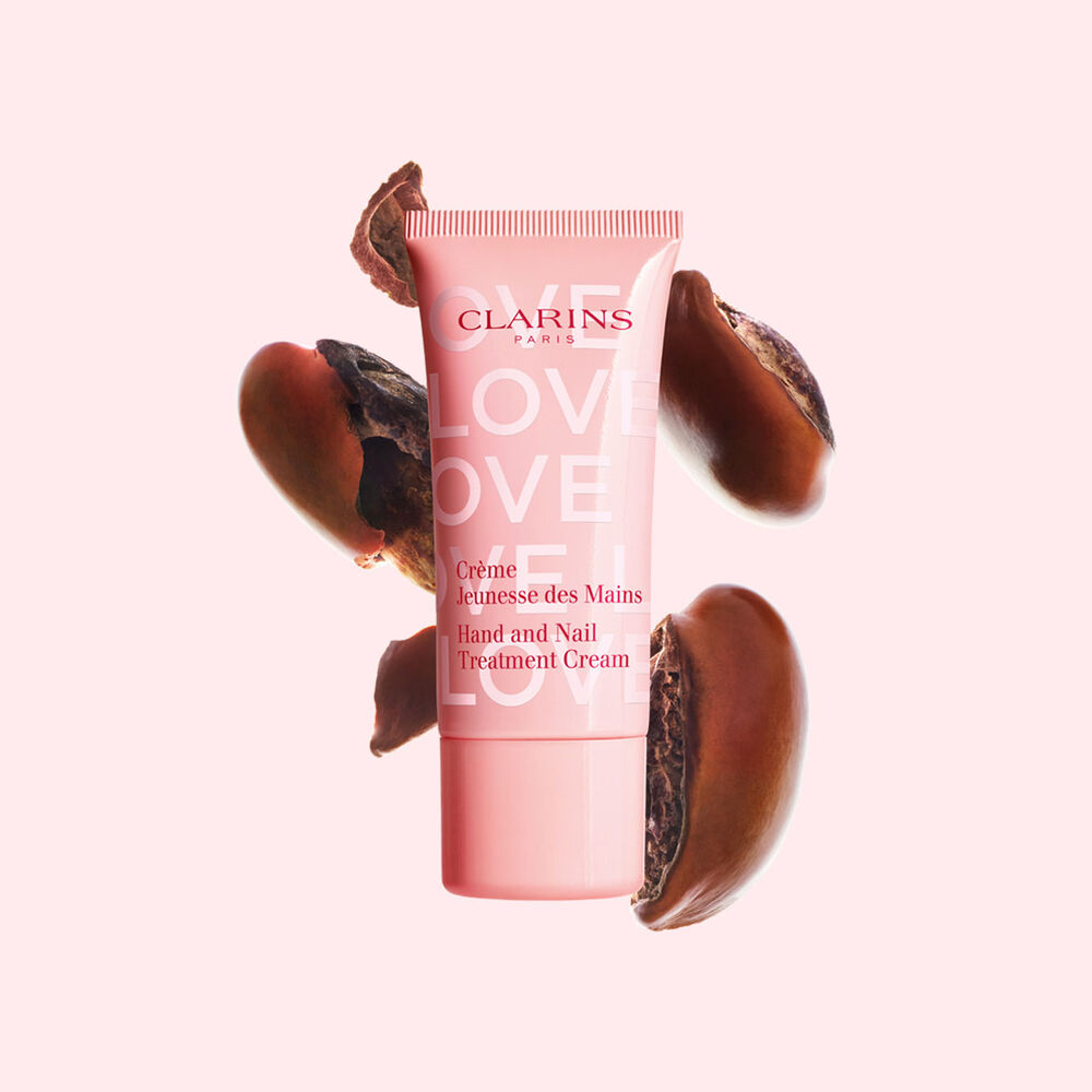 Packshot Hand Cream Limited Edition Love Collection -k&auml;sivoiteesta sheansiementen edess&auml; vaaleanpunaisella taustalla, joka korostaa tuotteen keskeist&auml; ainesosaa.