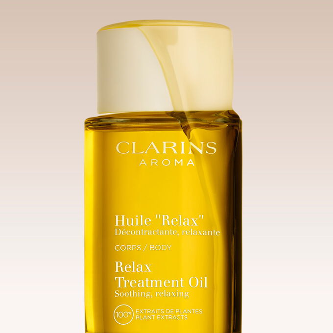 Kuva Clarins Relax Body Treatment Oil &ouml;ljyst&auml; kuvioitua taustaa vasten ja teksti, joka painottaa tuotteen rentouttavaa vaikutusta