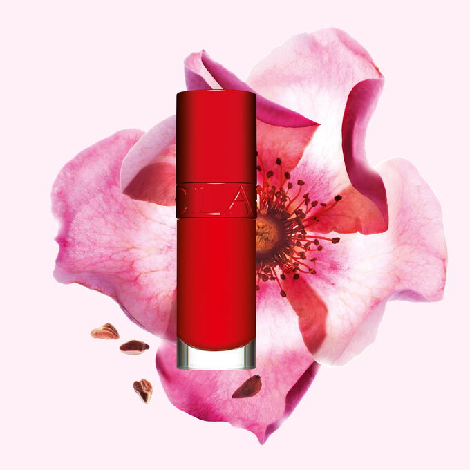 Packshot Clarins Lip Comfort Oil -tuotteesta Iconic Red -s&auml;vyss&auml;,  ruusumarjakukka musta-punaisella taustalla.