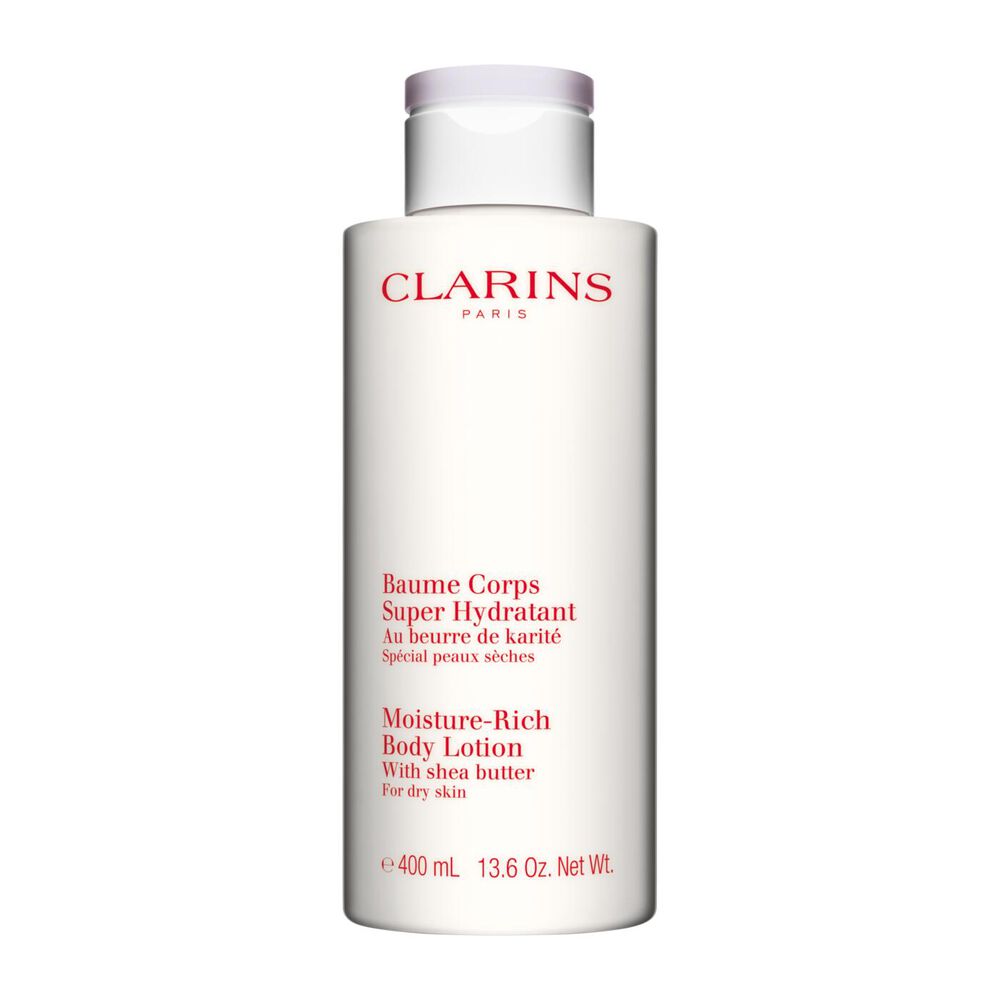 Kuva Clarins Moisture-Rich Body Lotion pullosta ja karitepuun p&auml;hkin&ouml;ist&auml; valkoista taustaa vasten.