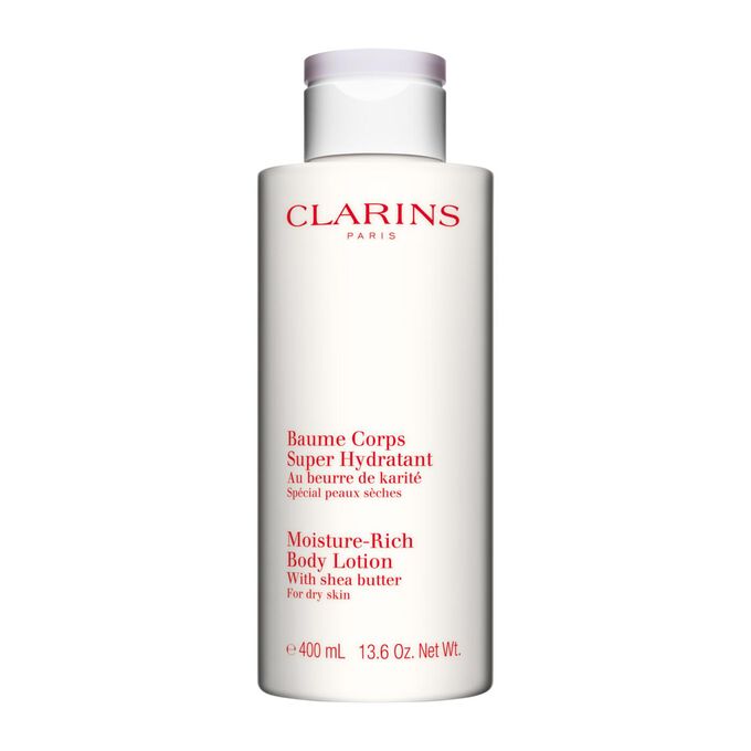Kuva Clarins Moisture-Rich Body Lotion pullosta ja karitepuun p&auml;hkin&ouml;ist&auml; valkoista taustaa vasten.