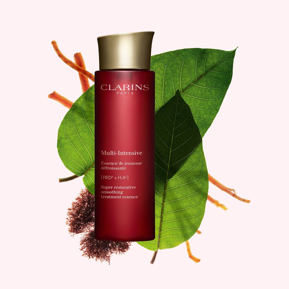 Kuva Clarins Super Restorative Treatment Essence esanssista, Jania rubensista, harunganan lehdist&auml; ja ginsengin juurista vaaleanpunaista taustaa vasten.