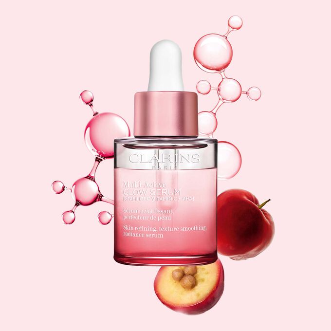 Multi-Active Glow Serum -pakkauskuva, jossa C-vitamiinimolekyyli ja acerola vaaleanpunaisella taustalla korostamassa ihon hehkua.