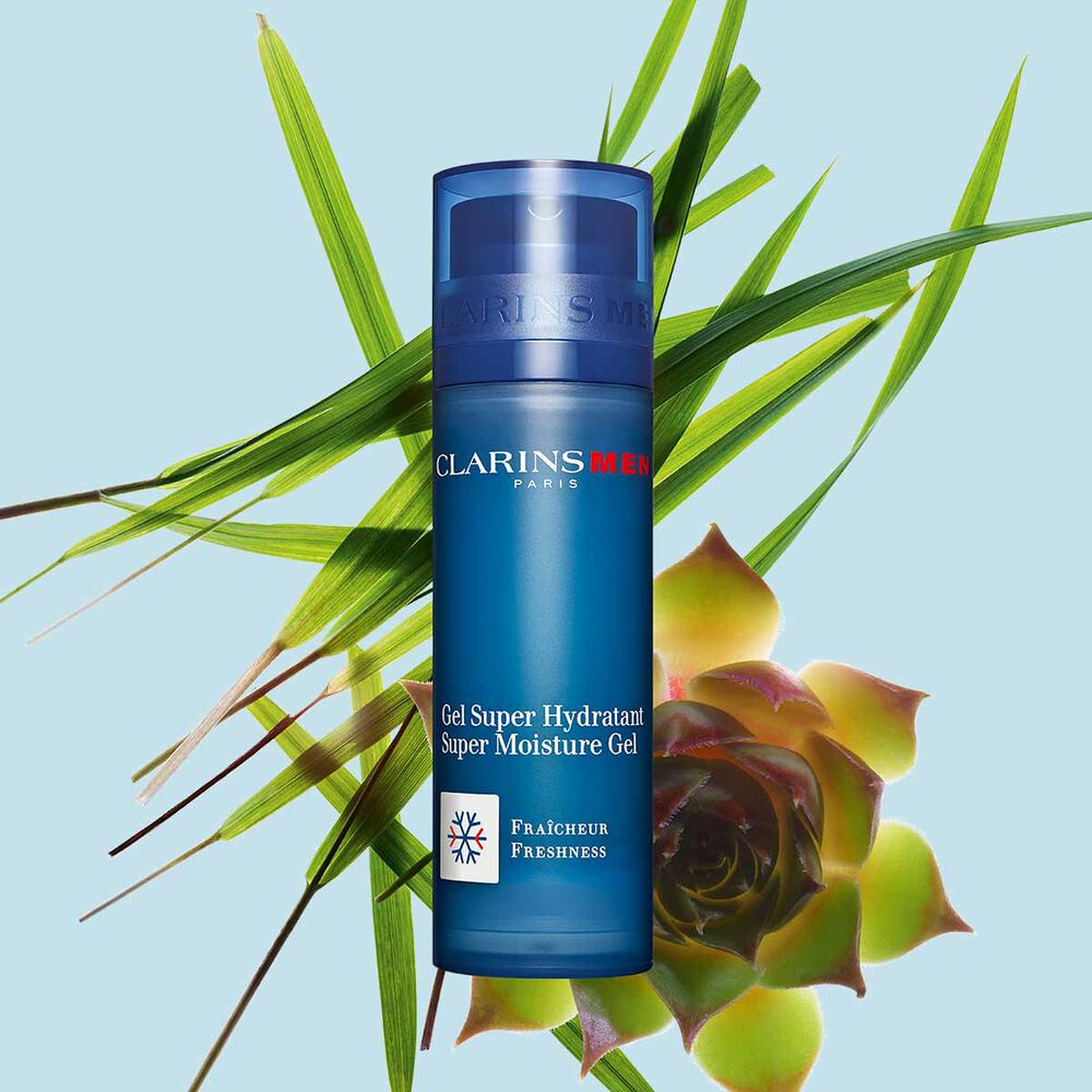 Kuva Clarins Men Super Moisture Gel pumppupullosta, oinaansarviliaanista ja puhveliheinästä sinistä taustaa vasten.