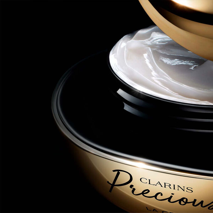 Kuva Clarins Precious Soft Cream voiteesta tummaa taustaa vasten, teksti vaikutuksesta, joka saa ihon n&auml;ytt&auml;m&auml;&auml;n 5 vuotta nuoremmalta