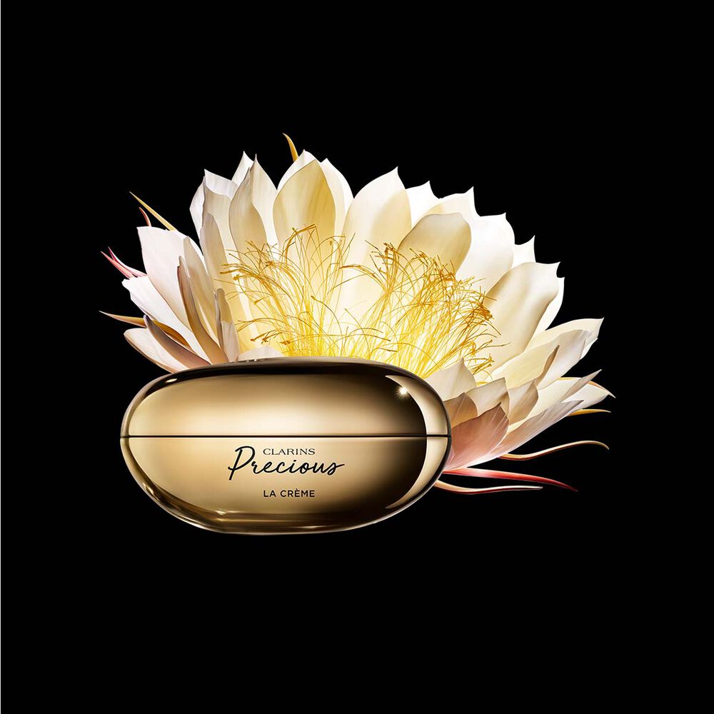 Kuva Clarins Precious Soft Cream voiteesta ja y&ouml;kaktuksen kukasta tummaa taustaa vasten.