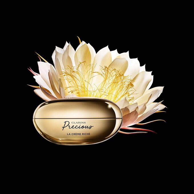 Kuva Clarins Precious Rich Cream voiteesta ja yökaktuksen kukasta tummaa taustaa vasten.