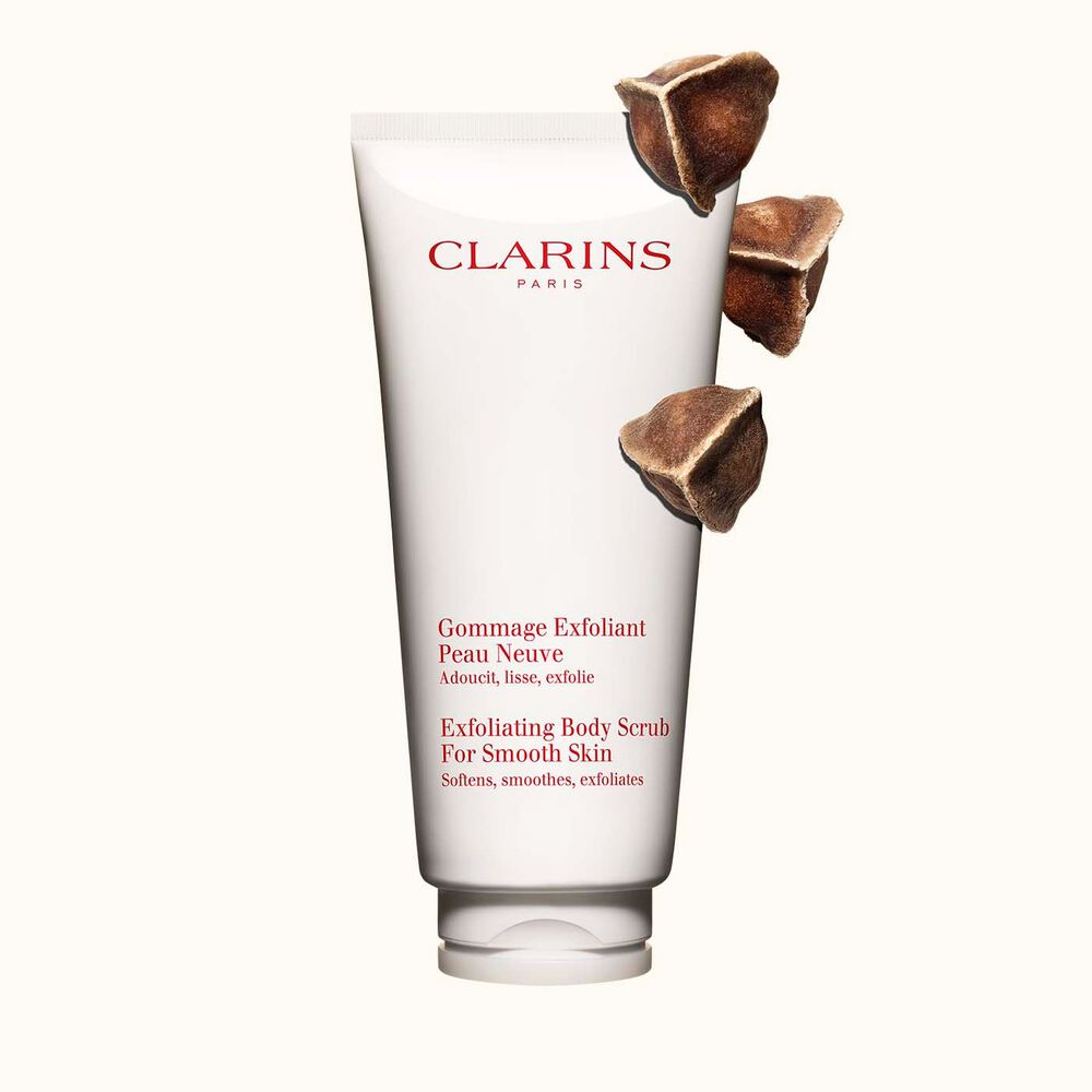 Kuva Clarins Exfoliating Body Scrub for Smooth Skin vartalokuorinnasta ja moringapähkinöistä vaalean beigeä taustaa vasten