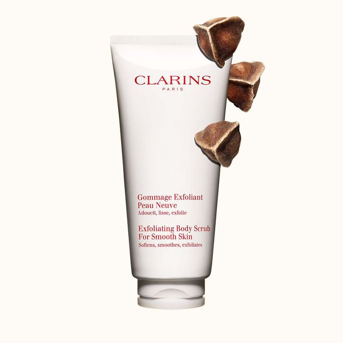 Kuva Clarins Exfoliating Body Scrub for Smooth Skin vartalokuorinnasta ja moringapähkinöistä vaalean beigeä taustaa vasten