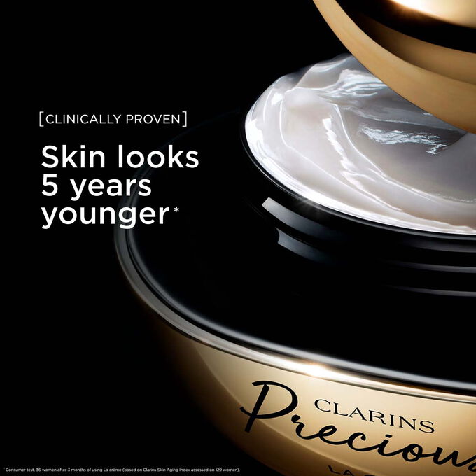 Kuva Clarins Precious Soft Cream voiteesta tummaa taustaa vasten, teksti vaikutuksesta, joka saa ihon n&auml;ytt&auml;m&auml;&auml;n 5 vuotta nuoremmalta