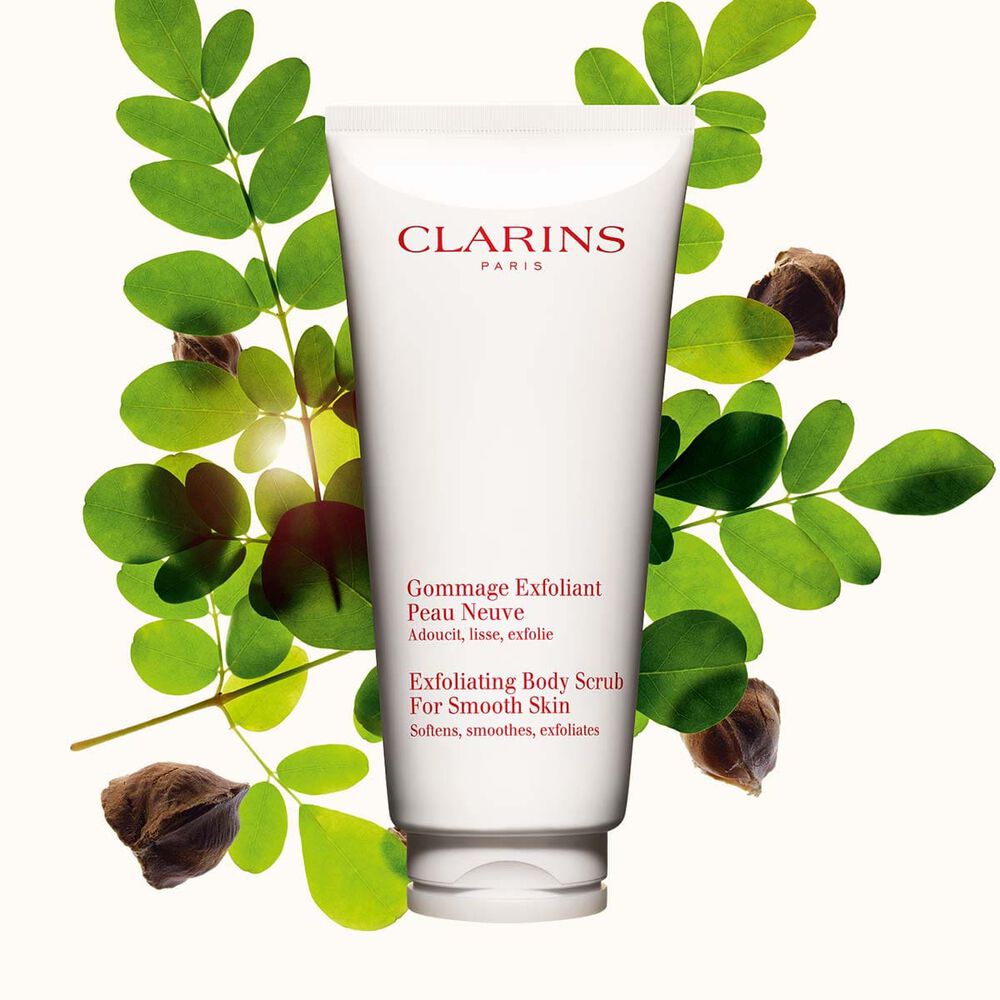 Kuva Clarins Exfoliating Body Scrub for Smooth Skin vartalokuorinnasta ja moringap&auml;hkin&ouml;ist&auml; vaalean beige&auml; taustaa vasten