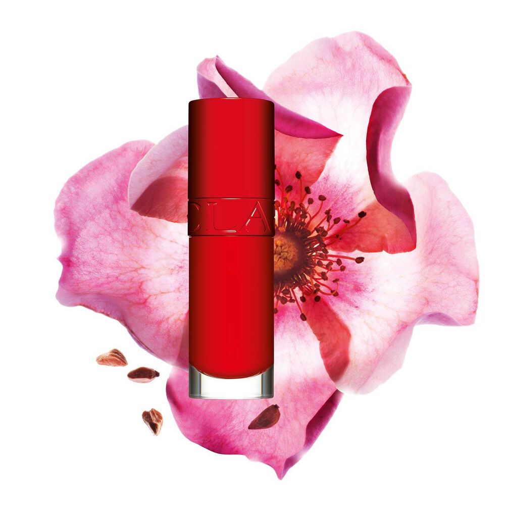 Packshot Clarins Lip Comfort Oil -tuotteesta Iconic Red -sävyssä,  ruusumarjakukka musta-punaisella taustalla.