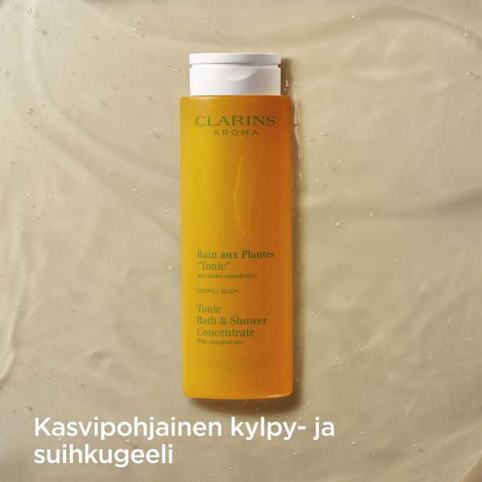 Kuva Clarins Tonic Bath and Shower Concentrate geelistä ja teksti suihkusaippuan tuoksuvasta kasvipohjaisesta koostumuksesta.