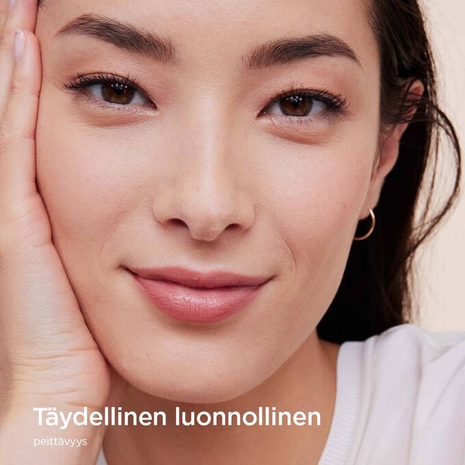Nainen, joka k&auml;ytt&auml;&auml; Clarins Skin Illusion Full Coverage -meikkivoidetta ja esittelee t&auml;yden peitt&auml;vyyden ja luonnollisen lopputuloksen.